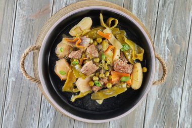 Siyah tabakta mevsimlik sebzeli kuzu güveci. Düz yatıyordu.