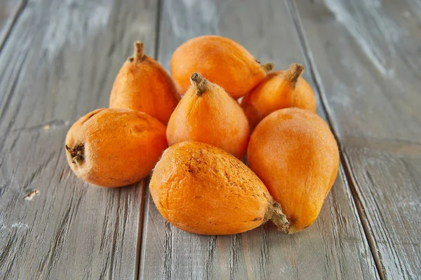 Medlar ripe, Loquats fruits Group of Japanese orange fruit medlars, exotic, juicy sweet plums on wooden background.