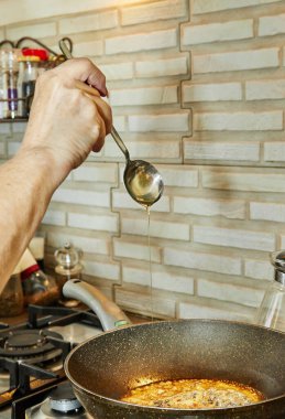 Şef turta yapmak için karamelli kızartma tavası hazırlar..