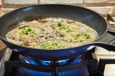 Izgara patates tabağı - Draniki evdeki gaz sobasında tavada kızartılıyor..