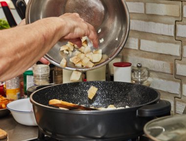 Chef pours the ginger into the cooking bowl.