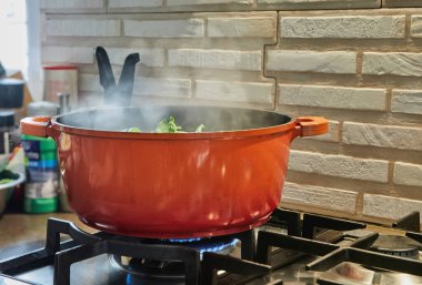 Chef blanched bunch of basil in simmering pot.