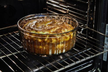 Cauliflower souffle in a transparent bowl in the oven after baking.