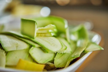 Sliced zucchini in glass bowl in home kitchen.