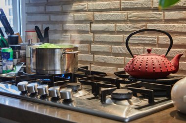 Head of cabbage is cooked in a saucepan on gas stove.