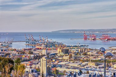 Hayfa, İsrail - 11 Mart 2023: Hayfa kentindeki deniz limanı, liman ve şehir binalarının mavi gökyüzüne karşı panoraması.