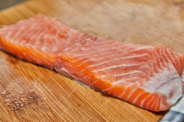 Şef somonu ıspanak, limon ve sosla pişirmek için kesiyor, fırında pişiriliyor. Fransız gurme mutfağı.