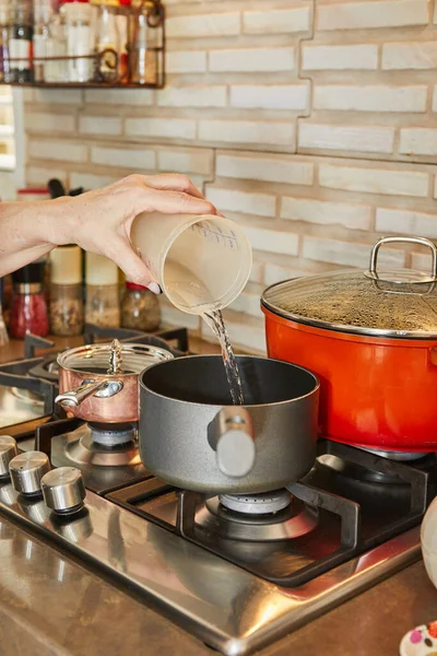 Bucătarul Toarnă Apă Dintr Ceașcă Măsurare Oală Aragaz — Fotografie, imagine de stoc