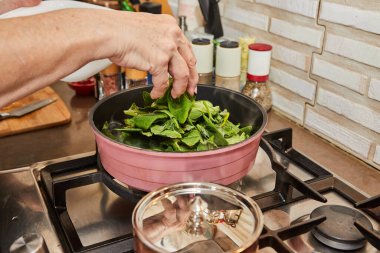 Şef, gaz sobasında yağda kızartılmış tavada kızarıyor..