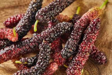 Gri ahşap arka planda siyah ve kırmızı Afgan dutu. Kapat..