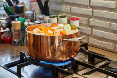 Gaz ocağında tabağı yanan bakır tencere..