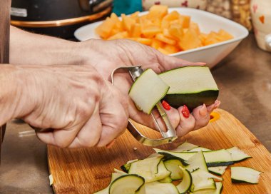 Chef cuts zucchini into slices in the home kitchen.