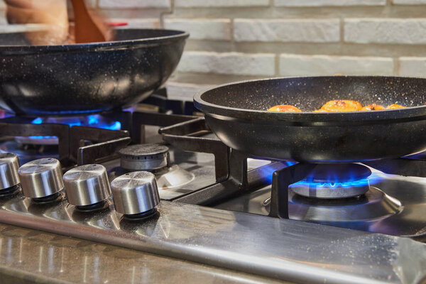 Сковородки на горелке огонь на газовой плите с блюдо готовится.