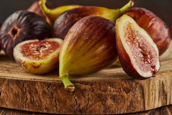 Figs on wooden background and wooden stands with shadows. Close up