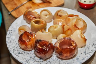 Doldurulanlar için arpacık soğanlarını bir tabağa koyun. Fransız gurme yemekleri..