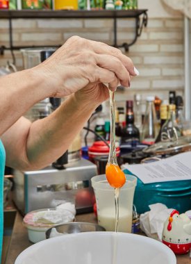 Aşçı, yemeği hazırlamak için sarıyı ve beyazı yener..