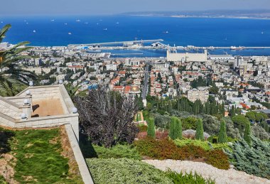 Hayfa, İsrail - 22 Ekim 2023: Bahai Bahçeleri Panoraması ve arka planda mavi gökyüzü bulutlu liman bölgesi.