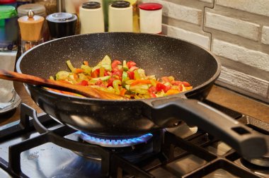 Kavurma tavası ve ahşap sopayla karıştırmak için gaz ocağında pişirilir..