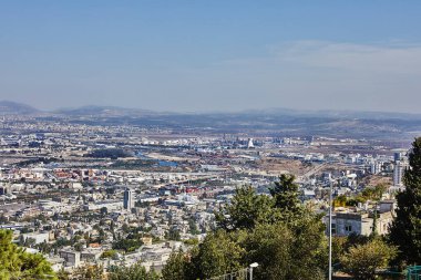 Hayfa, İsrail - 22 Ekim 2023: Sanayi bölgesi ve yerleşim alanının panoraması bulutlu mavi gökyüzüne karşı.