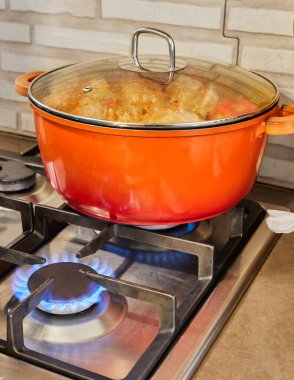 Doldurulmuş kabak ve biberler gaz sobasında üstü kapalı tavada pişirilir..