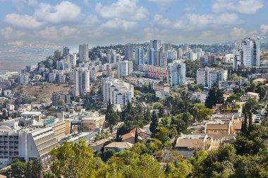 Hayfa, İsrail - 22 Ekim 2023: Şehir binalarının panoraması, yerleşim alanı bulutlu mavi gökyüzünün arka planına karşı.