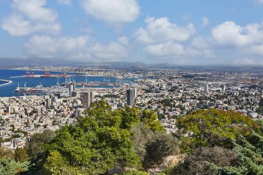 Hayfa, İsrail - 22 Ekim 2023: Hayfa kentindeki liman, liman ve şehir binalarının manzarası mavi gökyüzünün arka planında bulutlu.