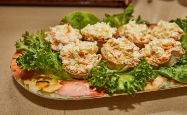 Çekici bir ev yapımı mutfak görüntüsü mermer tepside harika bir salata sergileniyor. Salata taze marul yaprakları ve yengeç çubuklarından oluşur, hafif ve doyurucu bir yemek yapar..