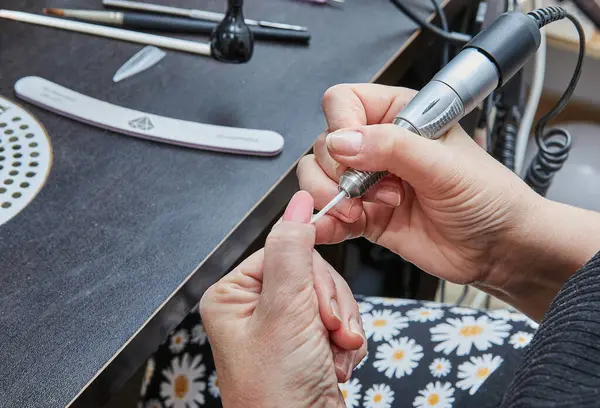 Witness the expertise of a nail technician as they skillfully apply gel nail extensions, expertly polish nails, and utilize a manicure machine to create stunning and immaculate hand nails.