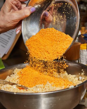 Renkli ve iştah açıcı kinoa salatası, çıtır çıtır ekmek kırıntılarıyla kaplı, modern bir mutfakta, parlak doğal ışık ve minimalist dekor ile sunulmuş, taze ve davetkar bir atmosfer yaratıyor..