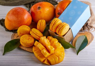 Masada çeşitli mango ve makaronlar sergileniyor, renkli doğal besinler sergileniyor. Meyve ve tatlıların kombinasyonu mutfağın çeşitli malzemelerini vurgular
