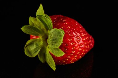 Lezzetli Çilek, parlak siyah bir tezgahın üzerinde dinleniyor. Bu canlı kırmızı meyveler lezzetli ve besleyici bir süper yiyecektir. Atıştırmak ya da yemek tariflerine eklemek için mükemmeldir.