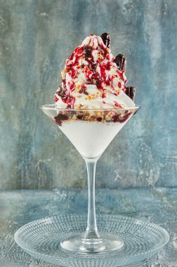 Tabaktaki bardakta bir milkshake 'in yakın çekimi, çeşitli malzemelerle yapılan kremalı içeceği sergiliyor ve içecek kabında servis ediyor.