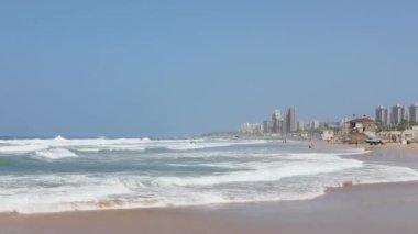 Sahile yakın büyük bir şehir, güneşli bir günde dalgalı dalgalar..