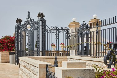 Arka planda limanı olan Bahai Bahçeleri 'nin manzarası ve bulutlu mavi gökyüzü..