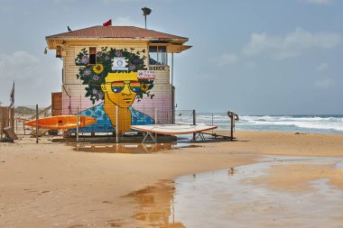 Hayfa, İsrail - 19 Nisan 2024: Akdeniz kıyılarındaki cankurtaran kulübesi Grafiti ve yansıma ile.