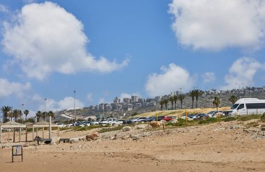 Hayfa, İsrail - 19 Nisan 2024: Hayfa şehrinin yerleşim alanına bakan deniz kıyısındaki kumsal.