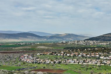 Tepeler ve dağlarla çevrili, yemyeşil bir vadiye kurulmuş, kırmızı çatıları olan güzel bir kasabanın daha yakın bir görüntüsü..
