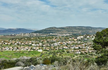 Tepeler ve dağlarla çevrili, yemyeşil bir vadiye kurulmuş, kırmızı çatıları olan güzel bir kasabanın daha yakın bir görüntüsü..