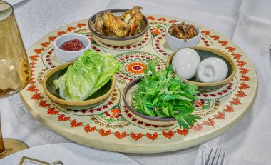 Geleneksel matzayla parlak bir Hamursuz Bayramı seti ve sembolik bayram yemekleriyle dolu güzel tasarlanmış bir Seder tabağı..