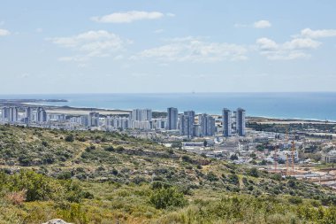 Yüksek binaları, yemyeşil tepeleri ve gün ışığında ışıldayan Akdeniz 'i olan kıyı kentinin panoramik manzarası.