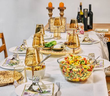 Canlı bir Hamursuz Bayramı yemeği masası renkli salata, geleneksel elementler, matza ve şenlikli yemek için hazırlanmış ayin yemekleri..