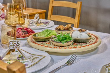 Geleneksel Hamursuz Bayramı yemeği, pancar jelatini içinde kırmızı balık ve güzel boyanmış tören tabağında sembolik eşyalar..