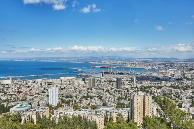 Hayfa, İsrail - 13 Nisan 2025: İsrail 'deki Hayfa limanına bakın, nakliye vinçlerini, kargo gemilerini ve Akdeniz kıyısındaki şehir siluetini vurguluyor.