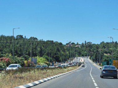 Hayfa, İsrail 24 Mayıs 2025: Güneşli bir yaz öğleden sonrasında eğimli sokakları, trafik ışıkları ve palmiye ağaçları olan büyüleyici bir İsrail mahallesi.