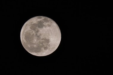 Dolunay, karanlık gece arkaplanındaki görünür yüzey kraterini parçalıyor.