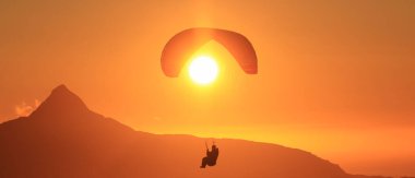 Norveç 'in kuzeyindeki BodExtreme' de Norveçli dağlarda Piraplander. Gece yarısı güneşinde paraglider (Midnatssol) güzel günbatımı gökyüzünde Keiservarden Dağı, Pod, Norveç