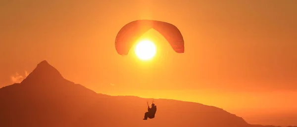 Norveç 'in kuzeyindeki BodExtreme' de Norveçli dağlarda Piraplander. Gece yarısı güneşinde paraglider (Midnatssol) güzel günbatımı gökyüzünde Keiservarden Dağı, Pod, Norveç