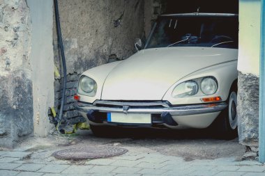White Citroen vintage car parked in old town arch of a brick building side view cleaned