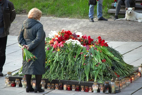 Old Woman Standing Snuffed Out Eternal Fire Surrounded Flowers Celebration — Stock Photo, Image