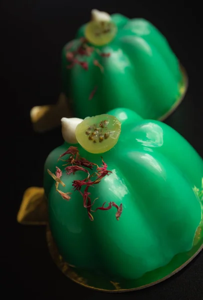 stock image Green gooseberry mousse modern desserts with mirror glaze topped with meringue kisses and berries on black background close